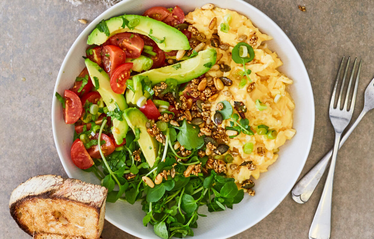 Magic mushroom breakfast scramble with fluffy eggs, avocado slices, and sautéed vegetables in a brunch bowl